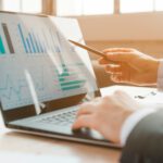 person analyzing business charts on laptop